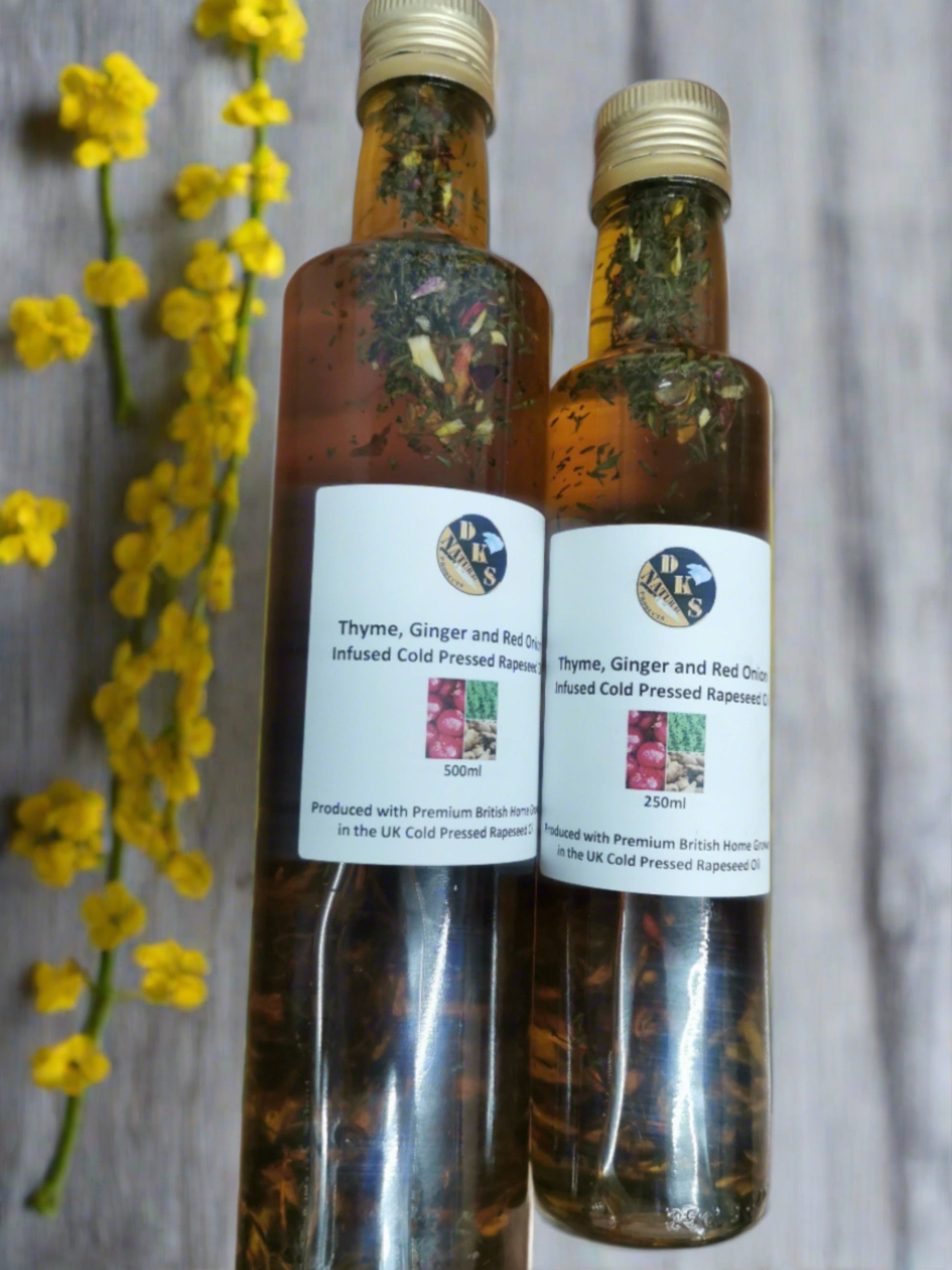 Thyme, ginger and red onion, infused rapeseed oil is in a glass bottle with some bits of thyme, ginger and red onion in the bottle as well as the rapeseed oil.