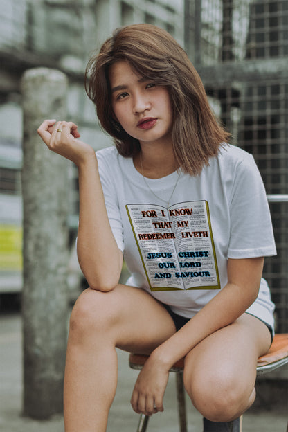 Woman wearing a white t-shirt with a printed design, sitting outdoors.