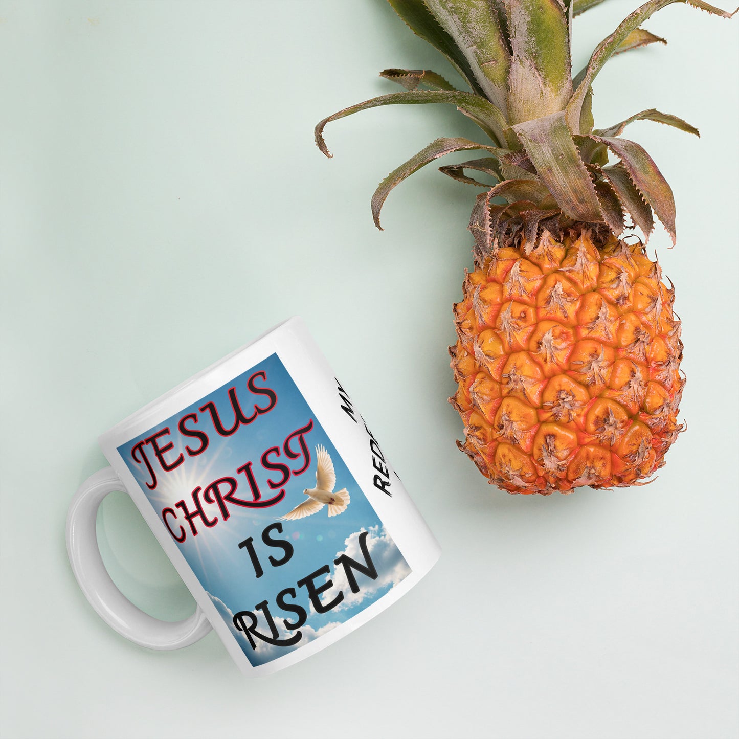 Start each morning with a reminder of hope and victory. This white ceramic mug features the uplifting phrase “Jesus Christ is Risen” on one side, and “My Redeemer” on the other, alongside a serene image of a dove — symbolizing peace and the Holy Spirit.